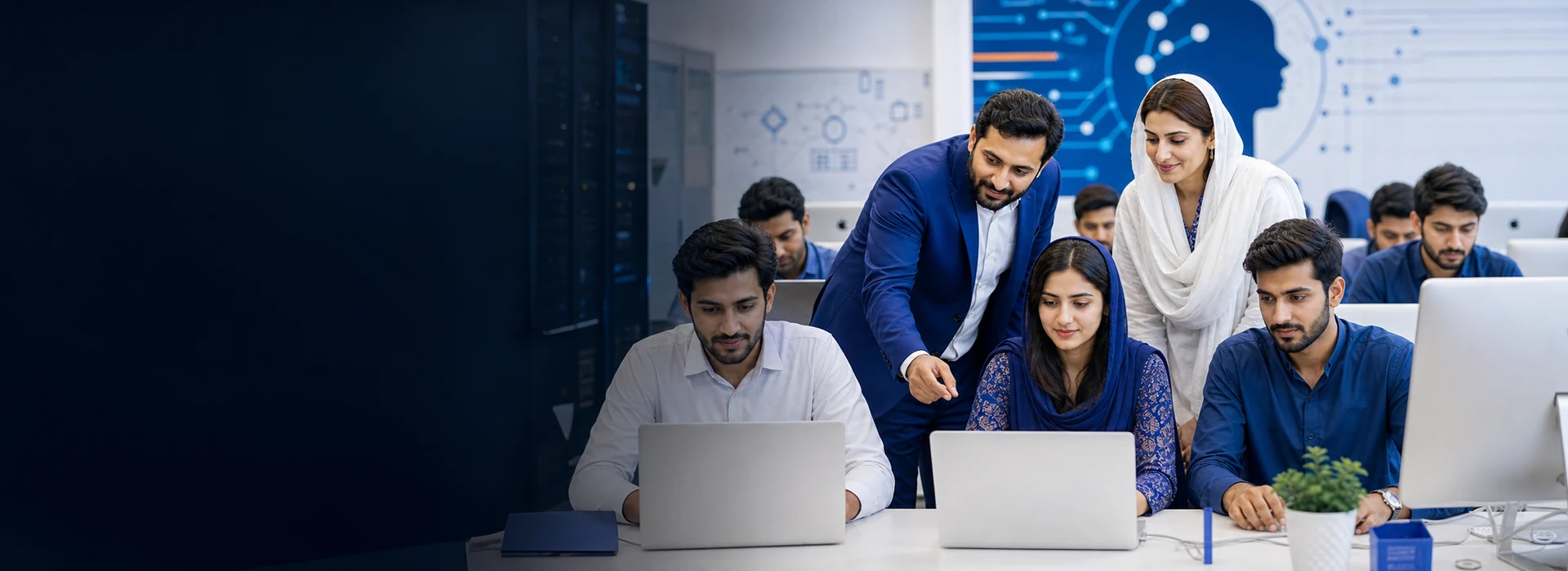 Pakistani technology instructors mentoring students in a modern computer lab
